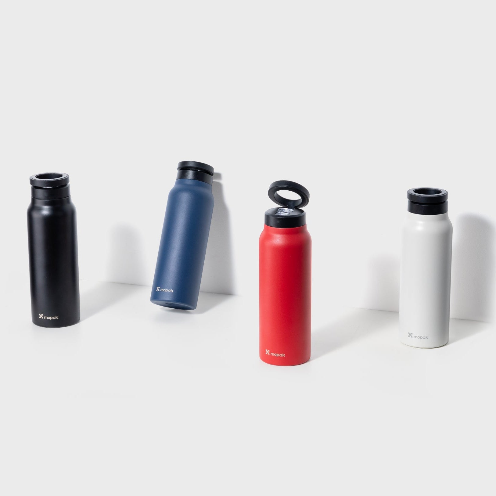 Smart Sip Bottle in black, blue, red, and white; a summer trend gym essential with stainless steel design and magnetic phone holder.