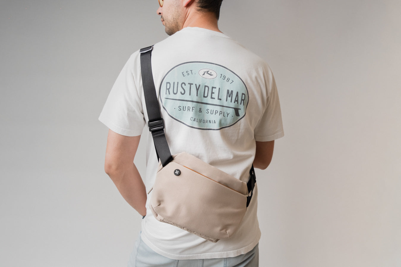 A man in while shirt is wearing mopak Wanderer Sling bag. The mopak logo shows very clear in the shot
