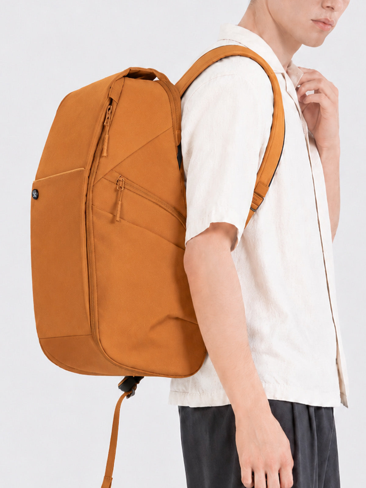 College student wearing an orange Urban Daypack for campus and commuting