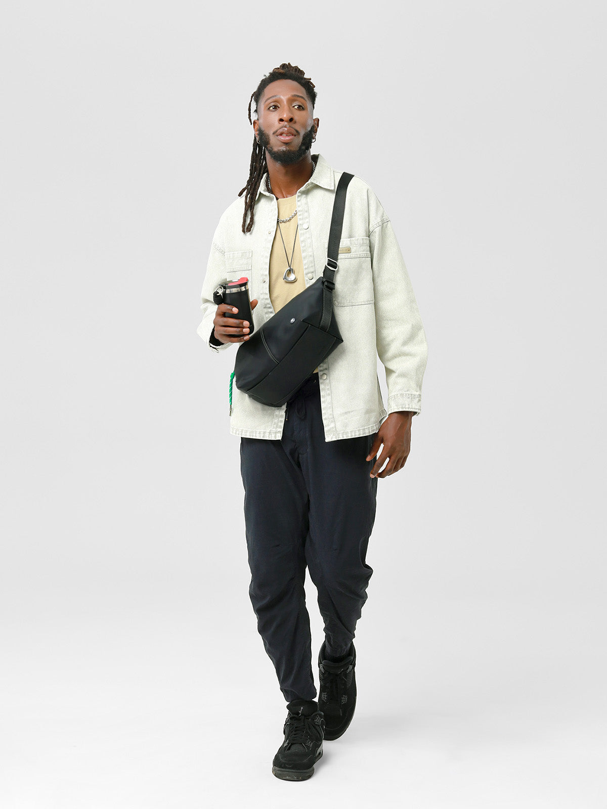 Model carrying the black MOPAK Urban Glide Crossbody Bag