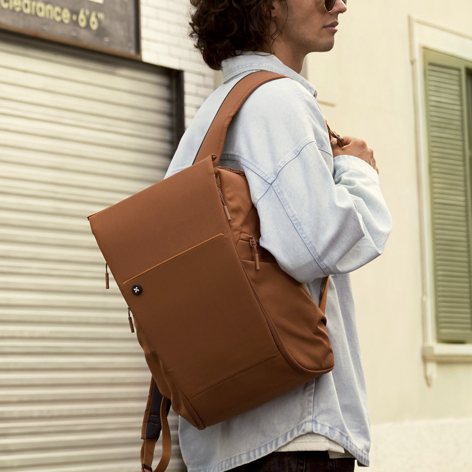 College student wearing an orange Urban Daypack for campus and commuting
