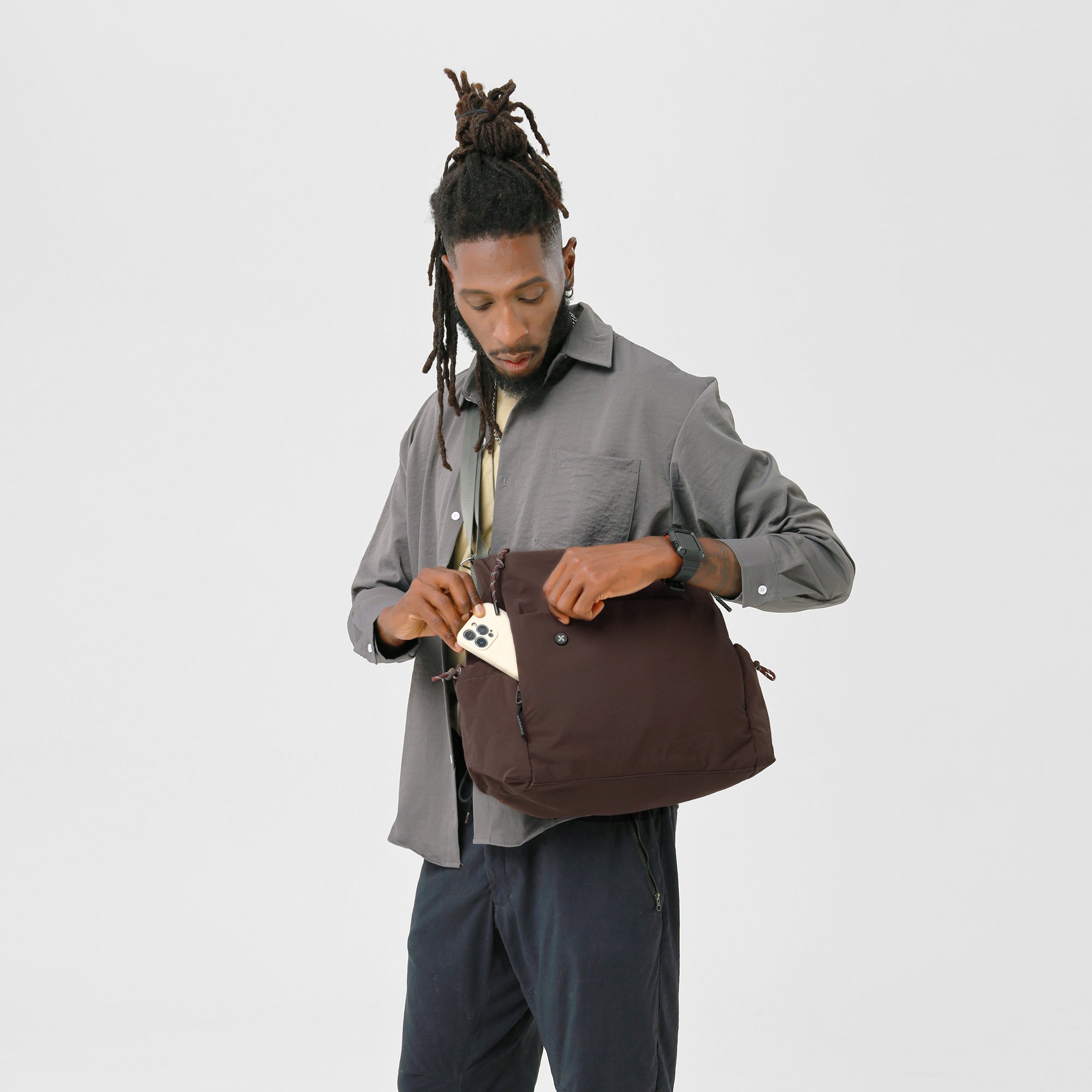 Person holding the Air Convert Tote made of organic fabric, showcasing its versatile style and function.