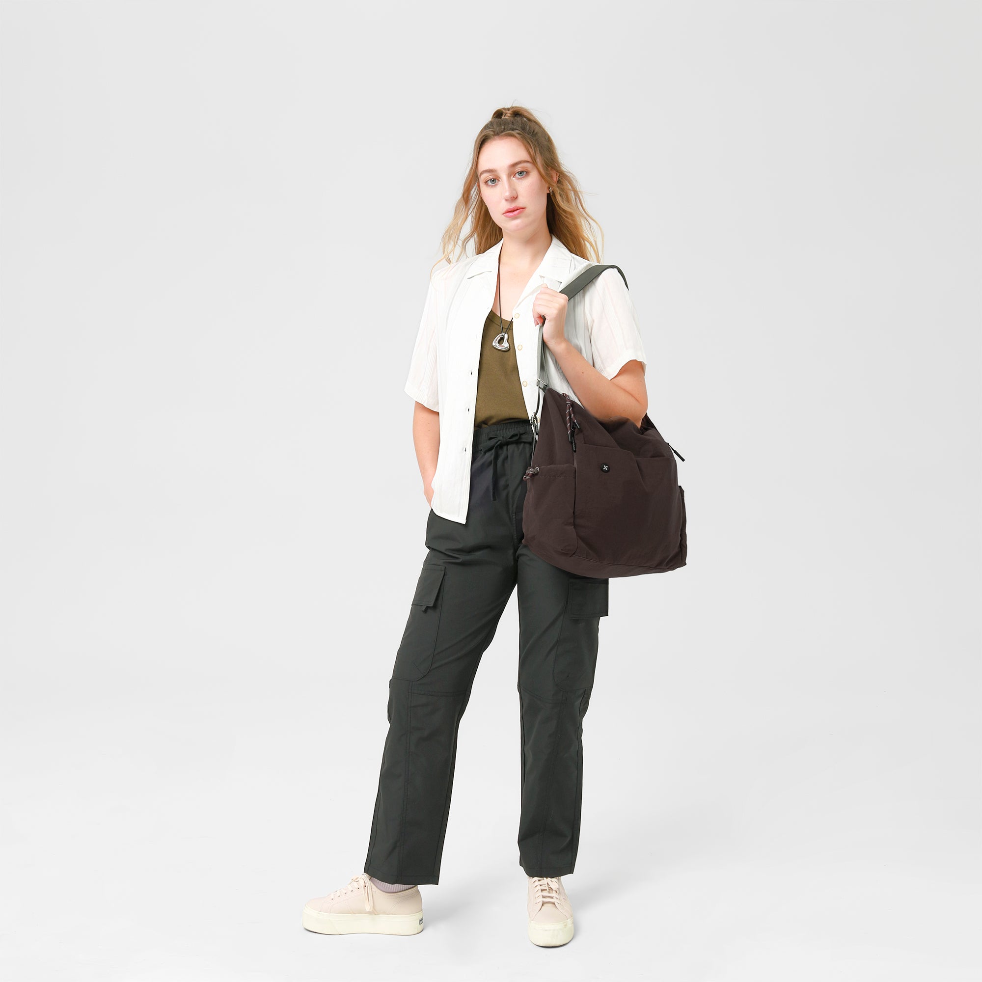 Model showcasing the Air Convert Tote in organic fabric, a versatile bag for urban style and comfort.