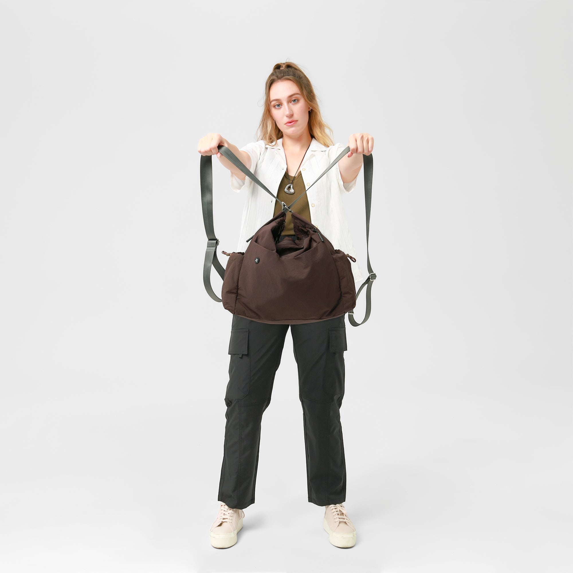 Model showcasing the Air Convert Tote, a versatile bag made from organic fabric, ideal for urban lifestyles.
