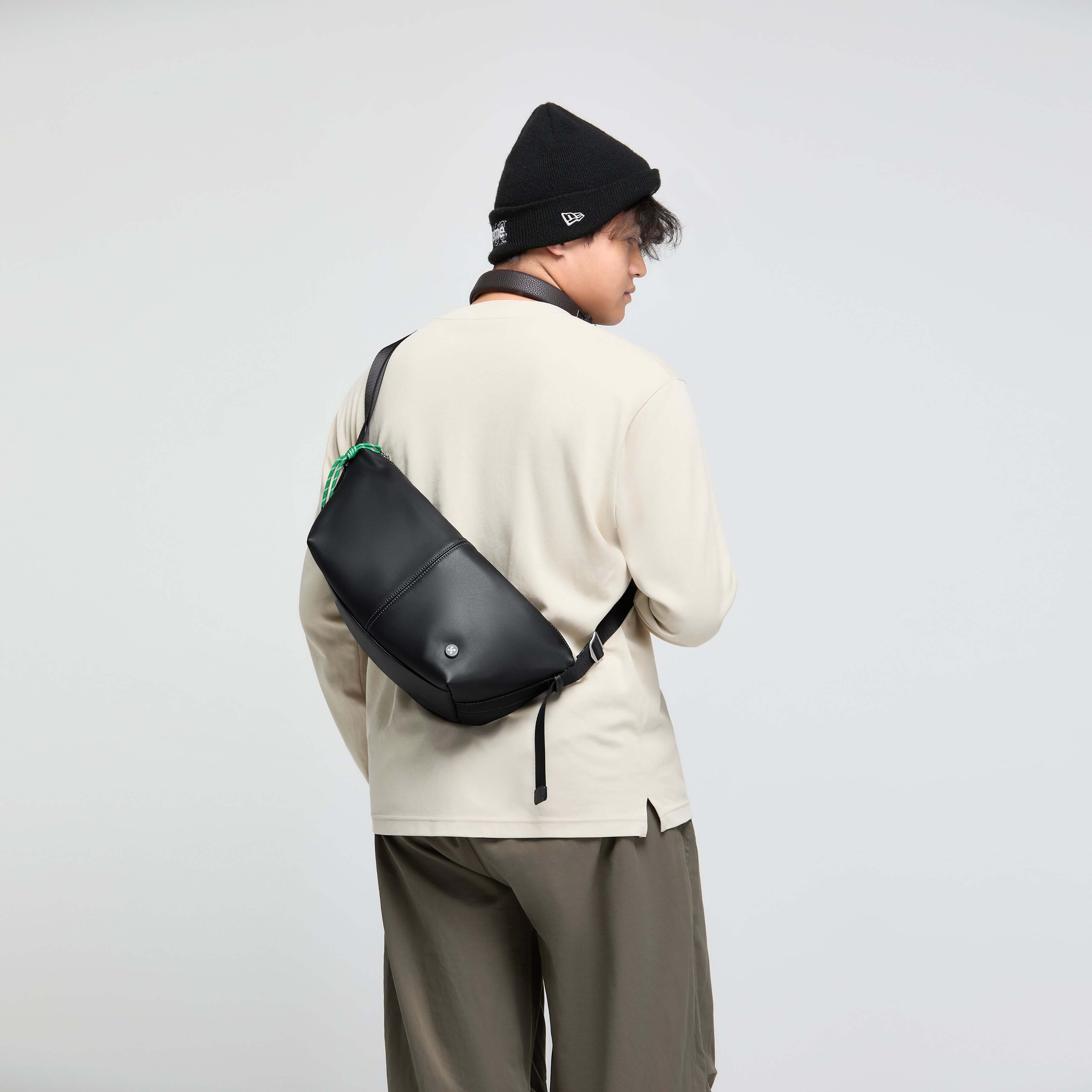 Man wearing the Urban Glide Crossbody with padded strap, crafted from rainproof coffee ground fabric.