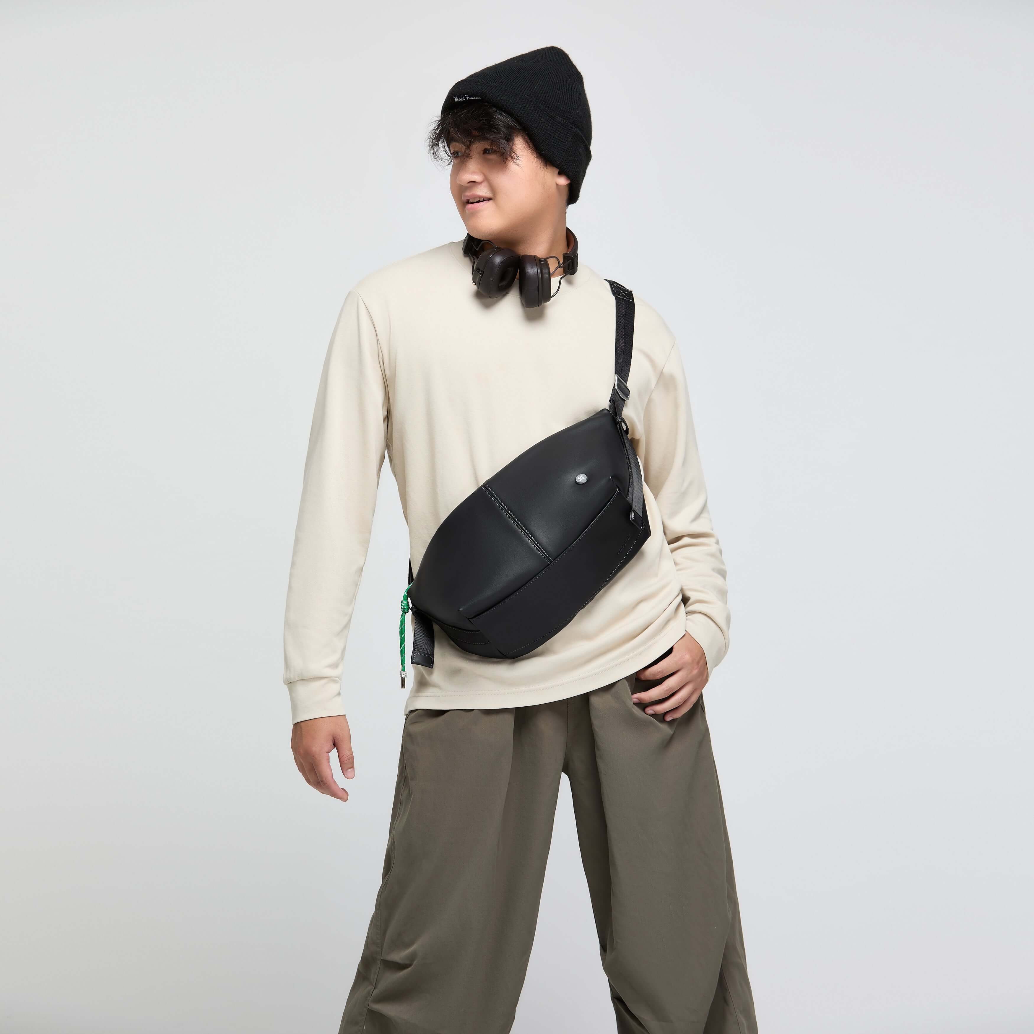 Model wearing Urban Glide Crossbody, featuring padded strap, rain proof design, and stylish coffee ground fabric.