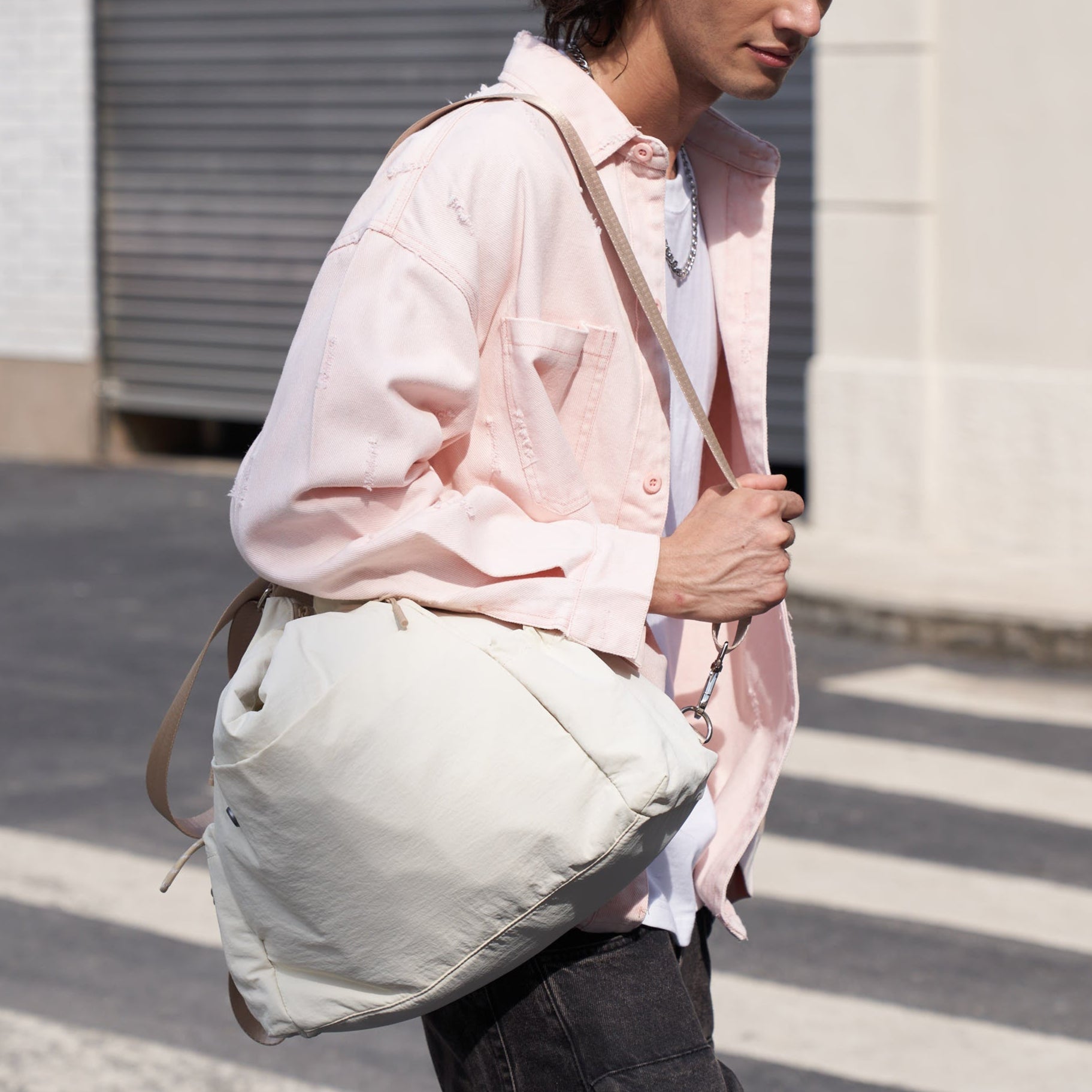 Person wearing mopak tote with one hand grabing the shoulder strap