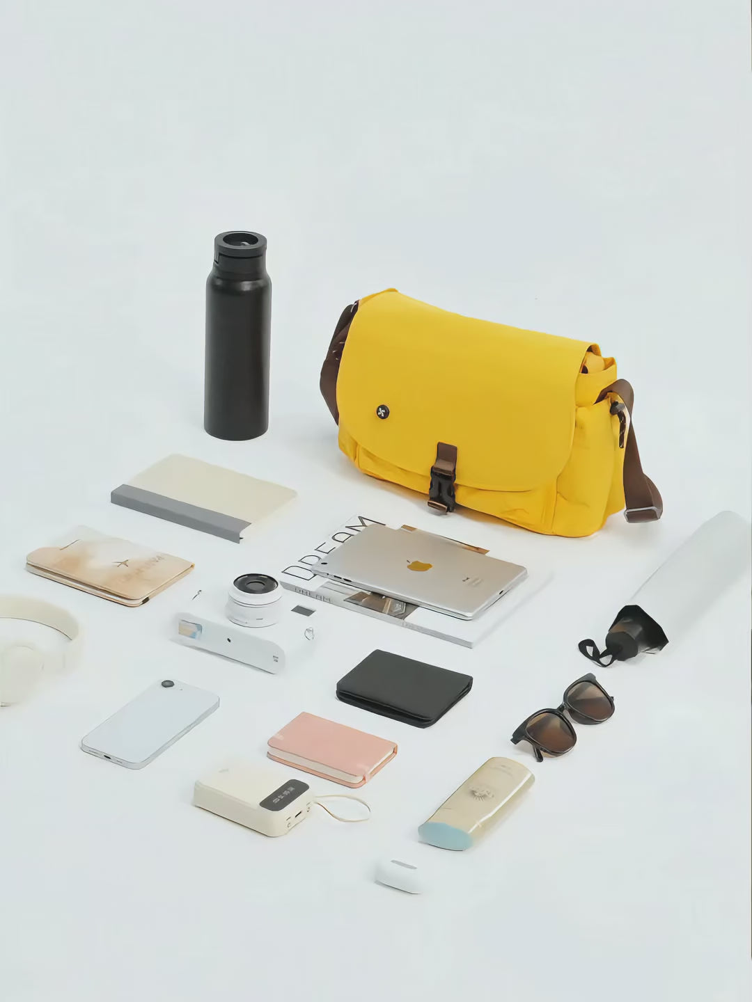 Coast Courier Bag displayed with various urban essentials, showcasing its versatility and colorful design.